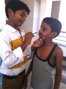 Class 8 student Daya Vardhan helps with make-up in the dressing room